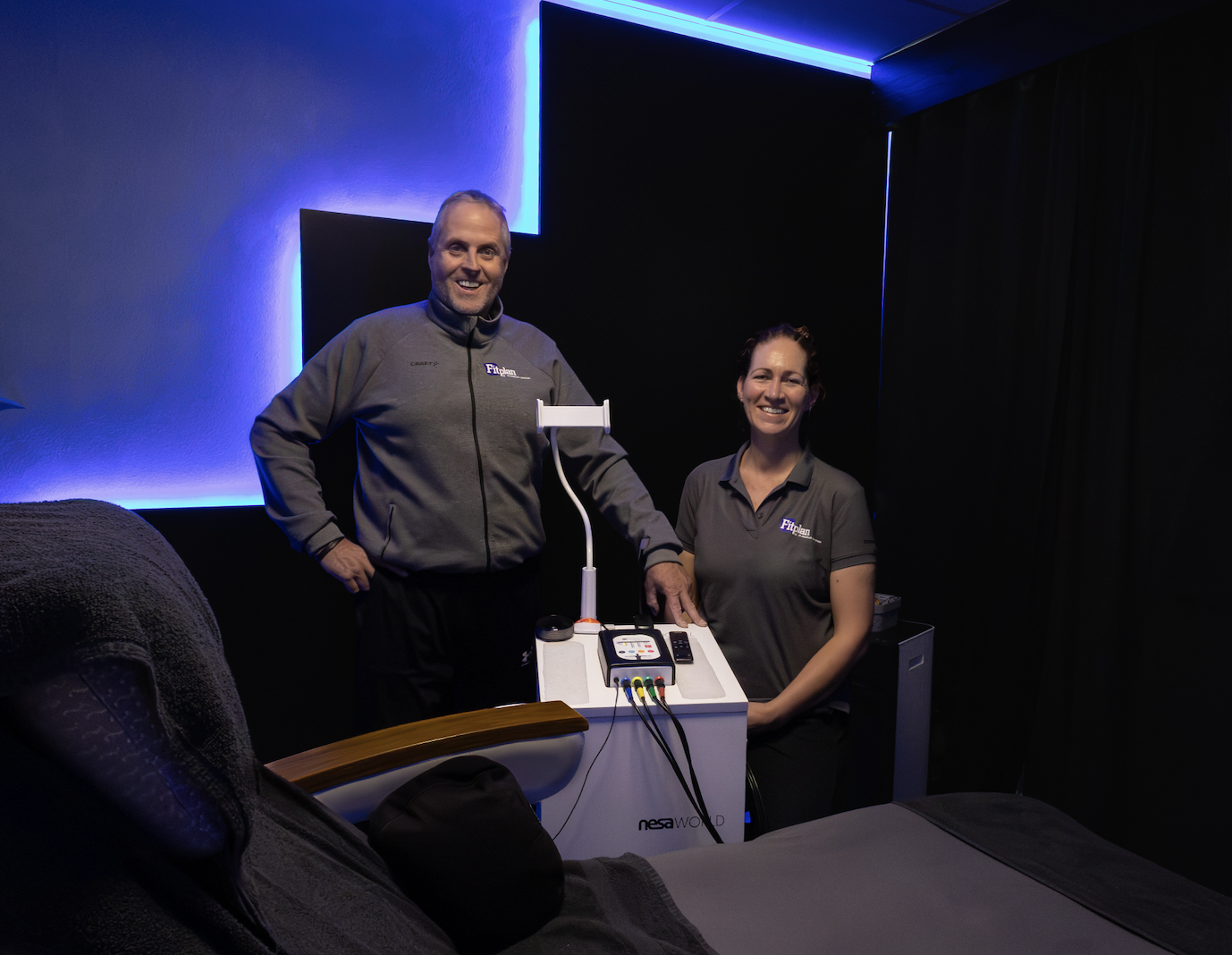 Fysiotherapeut Kim Glas en medisch fitnesstrainer Ronnie de Boer van NESAclinics Sneek met het NESA X-SIGNAL®-apparaat
